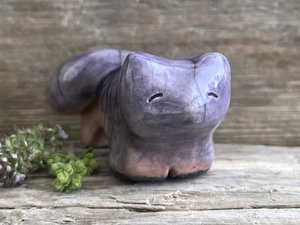raku ceramic kitsune fox sculpture glazed in a top-to-bottom gradient of soft violet to peach. it has a kind, gentle face, and a tail curled over its back.
