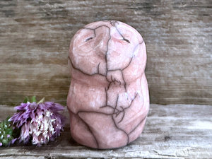 raku ceramic sculpture of what's probably an owl. it's glazed in a warm peach colour and has a kind, gentle, almost sleepy face.