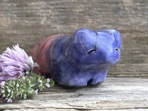 Ceramic raku bear kami sculpture glazed in a front-to-back gradient of indigo blue to soft red-pink. It has a kind, gentle face.