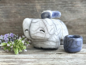 Raku ceramic white bear sculpture with a kind, gentle face. It carries a blue ceramic crescent moon on its back and has a little blue bowl too.