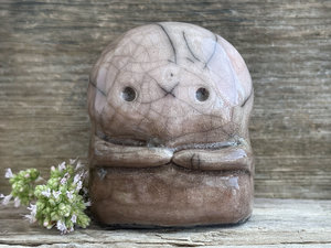 A kodama nature spirit ceramic guardian statue glazed in a bottom-to-top gradient of warm brown to pale peach-brown. It has a wide face, two big eyes, and cute little arms.