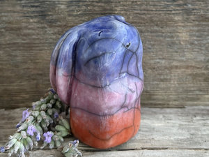 Raku ceramic usagi rabbit kami nature spirit glazed in a bottom-to-top gradient of burnt orange to mauve to indigo-violet. Its ears are folded down its back, and it has a kind, gentle face.