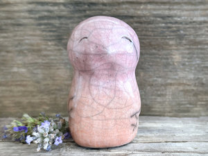 tall raku ceramic bird sculpture glazed in a bottom-to-top gradient of pale peach to pale rose pink. it has a kind, gentle face and feels very reassuring to hold.