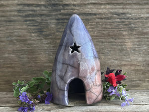 Raku spirit cave with two little windows (including a star-shaped one) and a dome-shaped door. It's glazed in a combination of soft indigo, violet, mauve, and burnt orange.