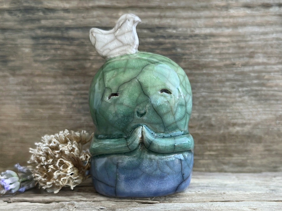Shinto Jizo nature spirit guardian ceramic statue glazed in a bottom-to-top gradient of blue and green with a happy, smiley face, little praying hands, and a sweet white bird on their head.