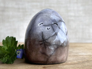 raku ceramic gnome spirit glazed in a bottom-to-top gradient of soft brown to indigo violet. it has a gentle, kind face.