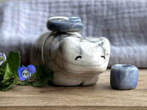 Raku ceramic white bear sculpture with a kind, gentle face. It carries a blue ceramic crescent moon on its back and has a little blue bowl too.