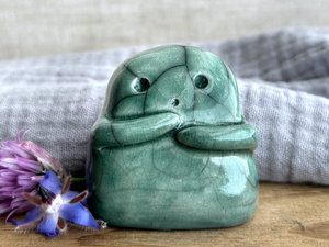 A sweet little kodama nature spirit ceramic guardian statue glazed in soft forest green and with a lovely, gentle face and little arms.