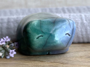 Raku ceramic bear kami sculpture glazed in forest green mostly on its left side and blue mostly on its right side. Where they overlap is a beautiful aqua colour. It has a kind, gentle face and is a little chonky.