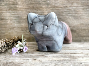 Raku ceramic kitsune fox sculpture glazed in a front-to-back gradient of soft blue to soft mauve pink. It has a kind, gentle face, and a tail curled over its back.