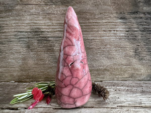Raku ceramic sculpture of a tall, pointy gnome. He is very friendly and glazed in a warm, soft red colour.