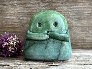 A sweet little kodama nature spirit ceramic guardian statue glazed in shades of green and with a lovely, gentle face and little arms.