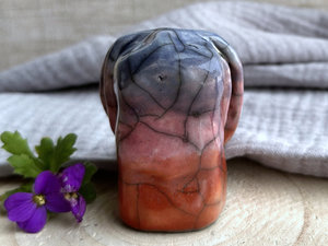 Raku ceramic usagi rabbit kami nature spirit glazed in a bottom-to-top gradient of burnt orange to mauve to soft indigo. Its ears are folded down its back, and it has a kind, gentle face.