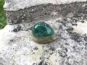Raku ceramic scupture of a hill spirit kami, an earth elemental nature spirit glazed in green and pale brown.