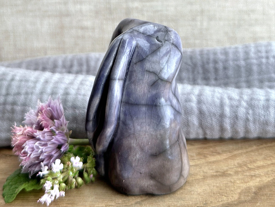 Raku ceramic usagi rabbit kami nature spirit glazed in a bottom-to-top gradient of warm brown to violet. Its ears are folded down its back, and it has a kind, gentle face.
