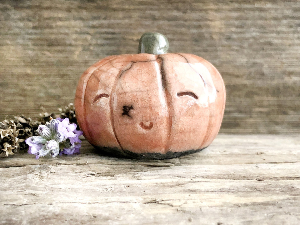Raku ceramic orange pumpkin nature spirit kami sculpture with a very happy, smiley face.