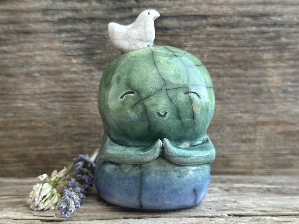 Shinto Jizo nature spirit guardian ceramic statue glazed in a bottom-to-top gradient of blue and green with a happy, smiley face, little praying hands, and a sweet white bird on their head.