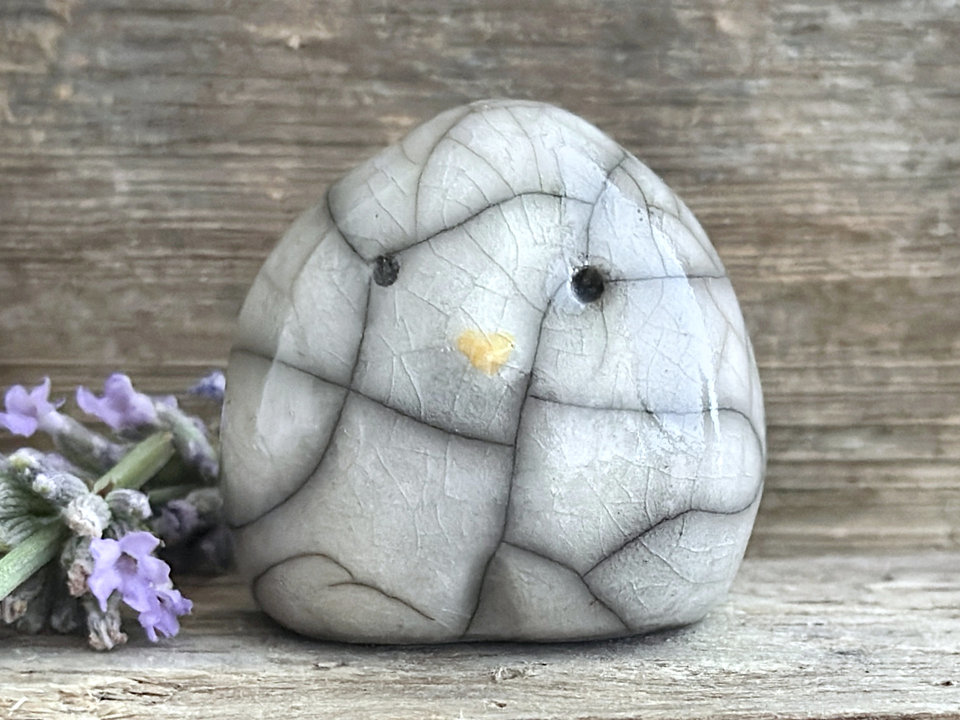 Raku ceramic little owl or owlet kami nature spirit statue glazed in white with gentle eyes and a little yellow beak.