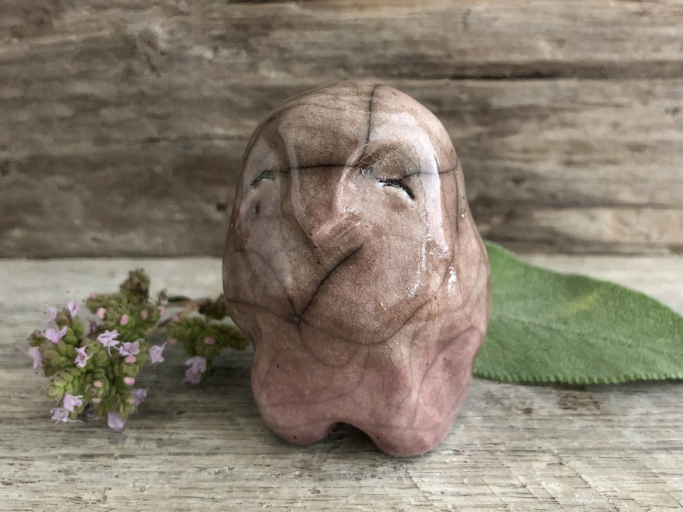 Raku ceramic standing owl / bird sculpture. He is glaze in a gradient from soft warm orange mauve to soft warm mauve brown from bottom to top. He has a kind, gentle face.