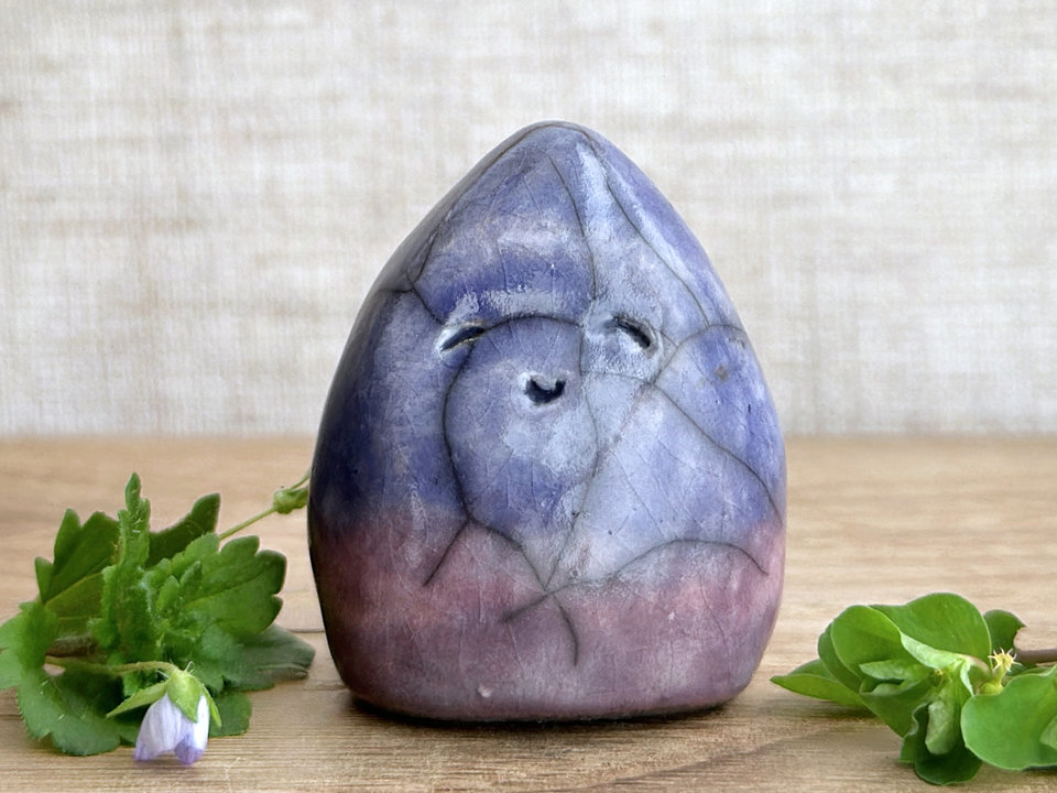 raku ceramic gnome spirit glazed in a bottom-to-top gradient of purple to indigo violet. it has a gentle, kind face.