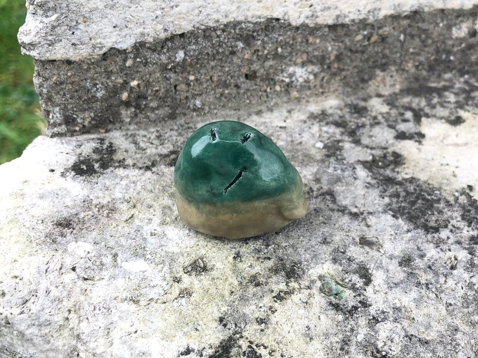 Raku ceramic scupture of a hill spirit kami, an earth elemental nature spirit glazed in green and pale brown.