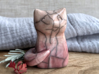 raku ceramic sitting fox glazed in a gradient from soft red to warm peach (bottom to top) with beautiful raku crackles. it has a kind face, and its tail is curled around it on its right side.