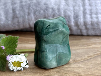 very small raku ceramic fox sculpture glazed in a forest-green colour. it has a gentle face.
