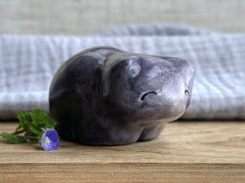 Ceramic raku bear kami sculpture glazed in grey violet with darker violet on its right side. It has a kind, gentle face and is a little chonky.