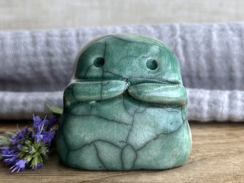 A sweet little kodama nature spirit ceramic guardian statue glazed in soft forest green and with a lovely, gentle face and little arms.