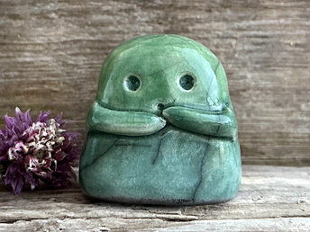 A sweet little kodama nature spirit ceramic guardian statue glazed in shades of green and with a lovely, gentle face and little arms.