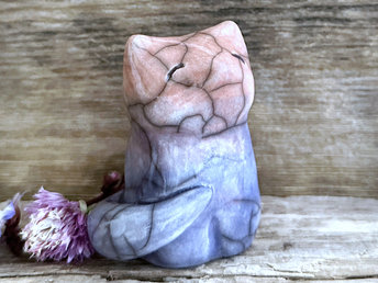 A calm and gentle Shinto Inari kitsune fox kami spirit ceramic raku statue glazed in a bottom-to-top gradient of blue to purple to soft peach. Its tail is curled around its body on its right side.