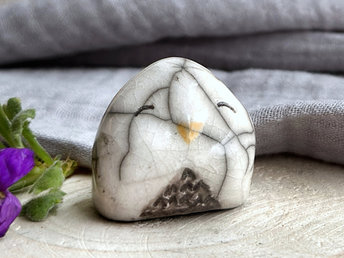 Raku ceramic little owl or owlet kami nature spirit statue glazed in white and grey with gentle, smiling eyes and a little golden yellow beak.